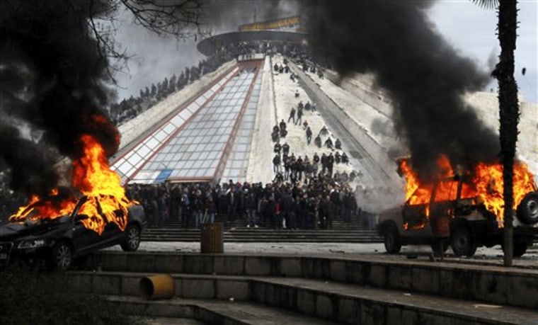 Opposition supporters are seen as vehicles burn following clashes with police during a protest in Tirana, Albania, on Friday. 
